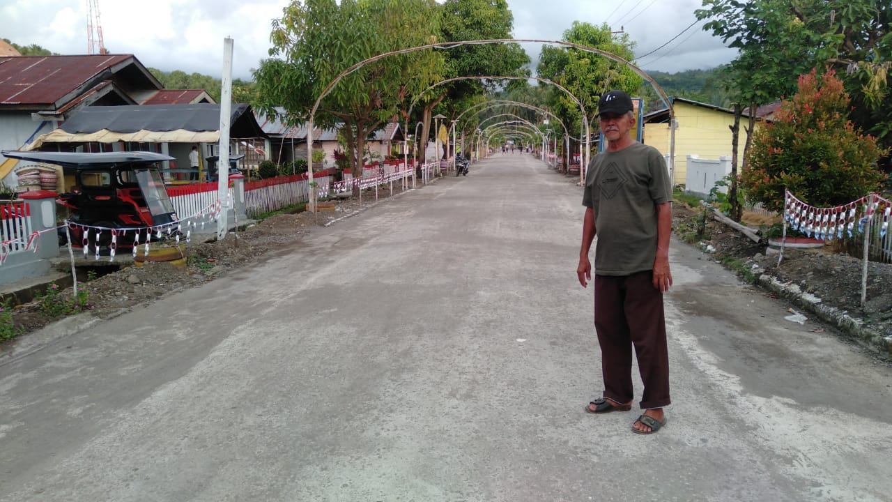 Aladin Gobel Sangadi Lolan Dua saat berpose dalam pekerjaan pelebaran bahu jalan desa