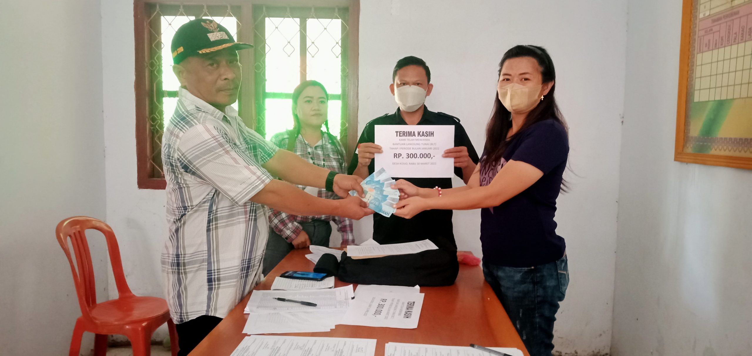 Irwan Suid Sangadi Kosio saat menyerahkan secara simbolis BLT DD ke KPM bertempat do Ba;ai desa Kosio Kecamatan Dumoga Tengah