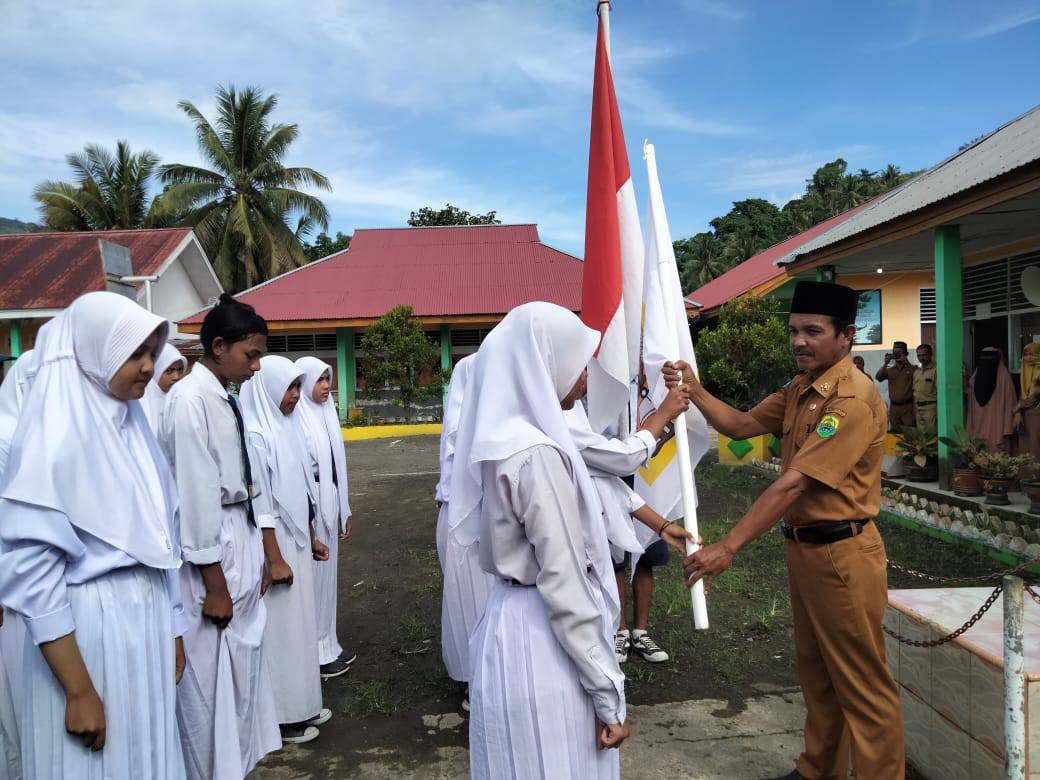 Kepsek SMPN 1 Paleleh Mustawa saat memberikan bendera pataka Osis kepada pengurus baru, usai melantik di Lapangan Upacar bendera, Senin (29/8/2022)