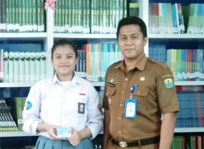 Marsya Siswi SMKN II Biau, warga Buol pertama warga Buol pertama yang KTP nya dicetak dan langsung diterima ditempat oleh tim Dukcapil bersama Kadis Dukcapil Mohamad Adsan.