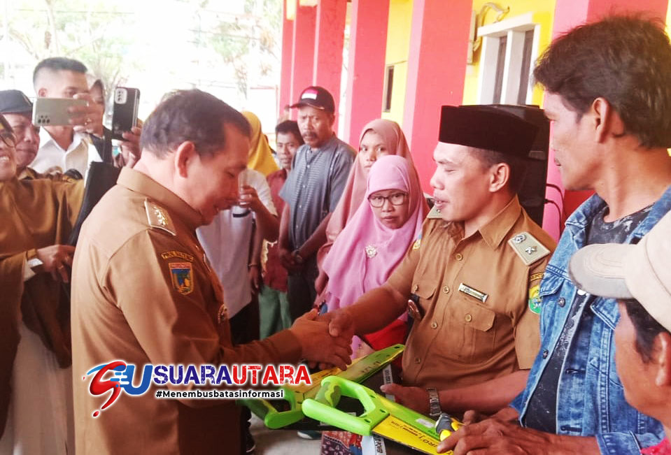 Pj Bupati Buol Drs M Muchlis, M.Si saat menyerahkan bantuan alat pertukangan secara simbolis yang diterima Kades Hulubalang Arlan L Amalu, Senin 5 Desember 2022.