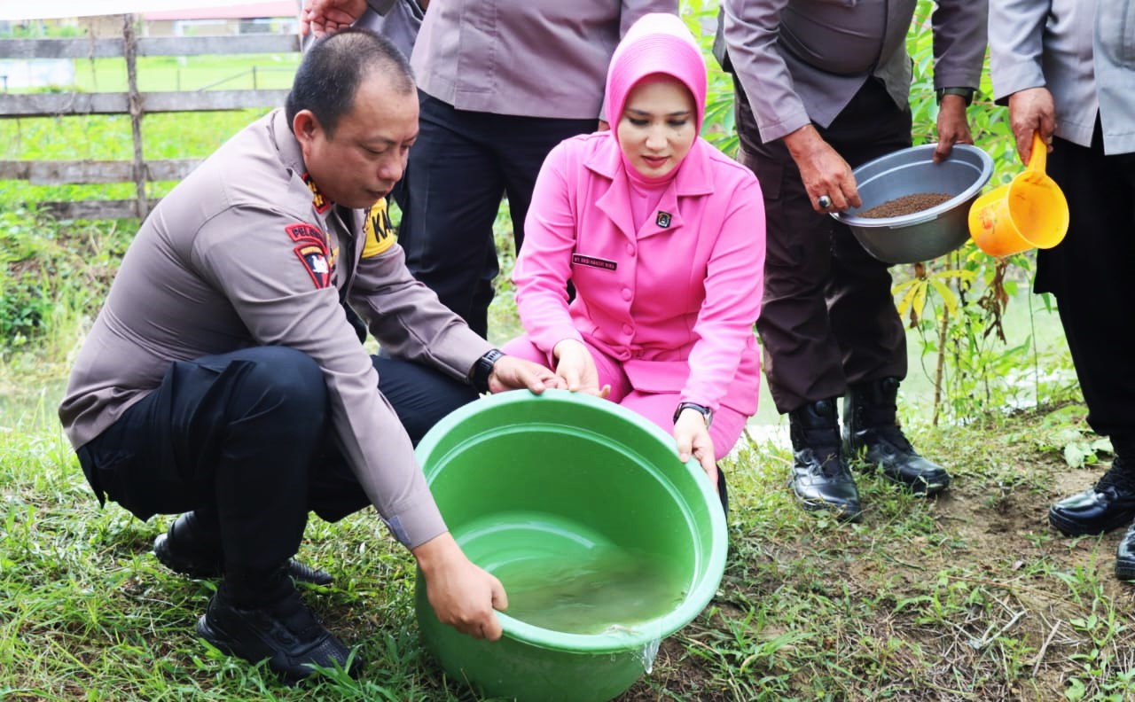 Kapolres Buol AKBP Handri Wira Suriyana,S.I.K,M.A.P bersama ketua Bhayangkari Cab. Buol Ny, Eksi Handri, saat melakukan pelepasan bibit ikan. (Foto Humas)