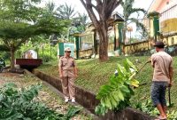 Sigap ! Sekdis DLH Ajak Staf Bersih-bersih Halaman Kantor dan Drainase