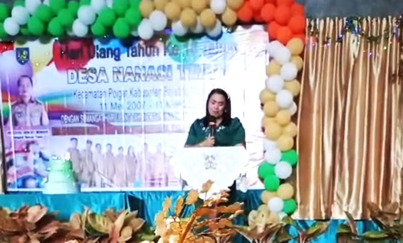 Camat Poigar, Alfina Sumenda saat memberikan sambutan di HUT Desa Nanasi Timur.