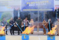 Foto para pejabat yang hadiri pemusnahan rokok ilegal sedang membakar barang bukti dan pemehan minuman berakohol