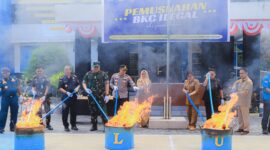 Foto para pejabat yang hadiri pemusnahan rokok ilegal sedang membakar barang bukti dan pemehan minuman berakohol