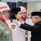 Foto Bupati Ir H.Amirudin Saat sematkan tanda kebangkitan pada salah satu pembawa bendera pusaka