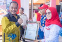 Foto Mujiono Lasitata saat menyerahkan piagam bagi petugas PMI 